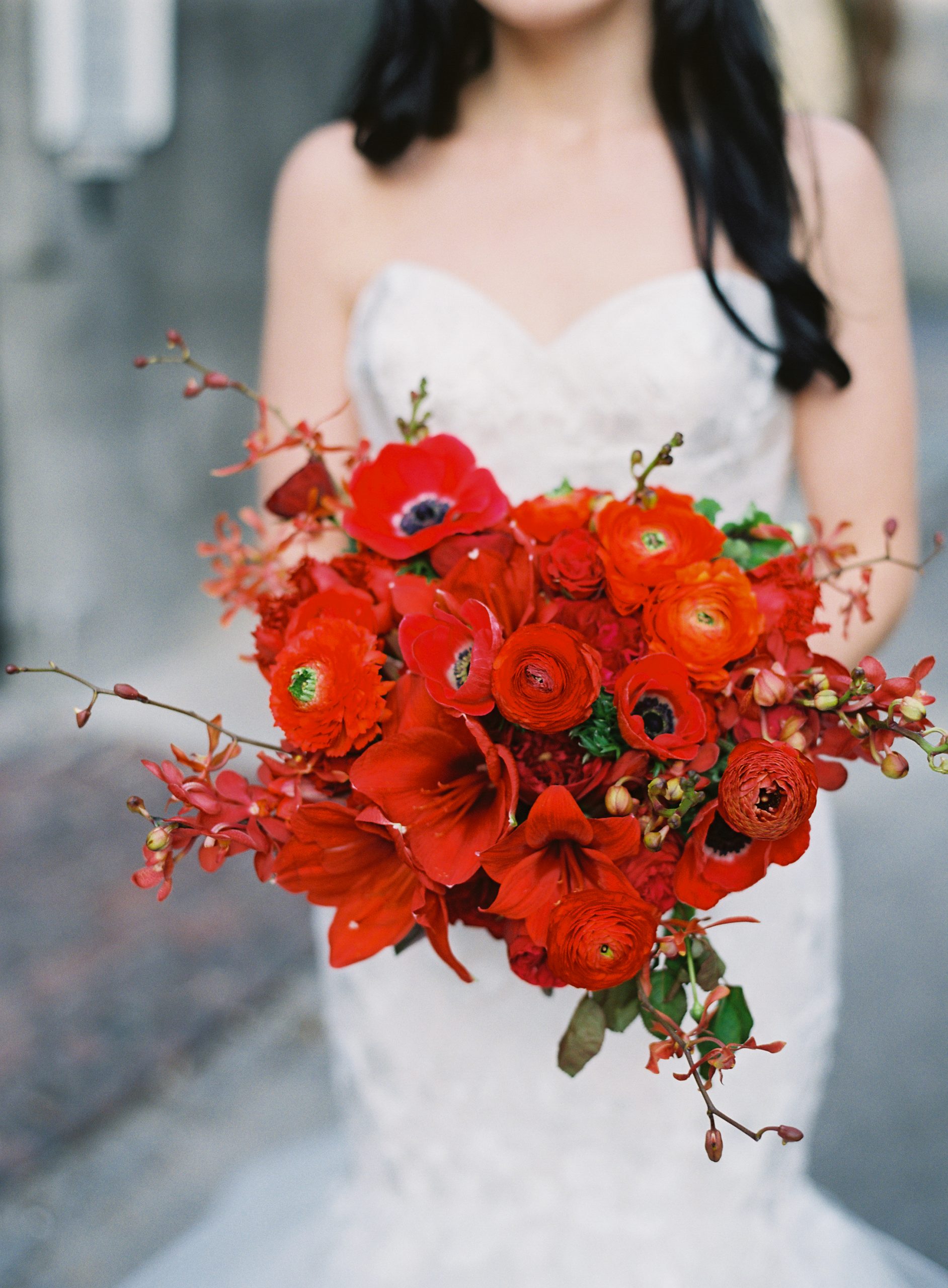 bride holding a red flower bouquet